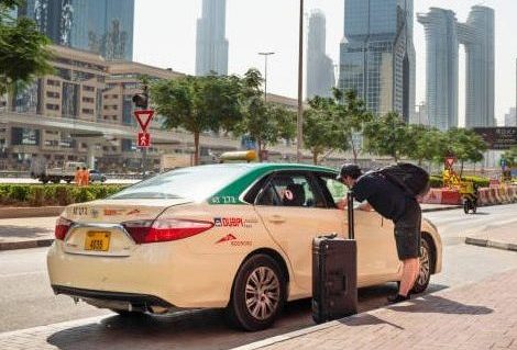 November 20, 2021 UAE, Dubai - tourist with a suitcase stops a taxi in Dubai